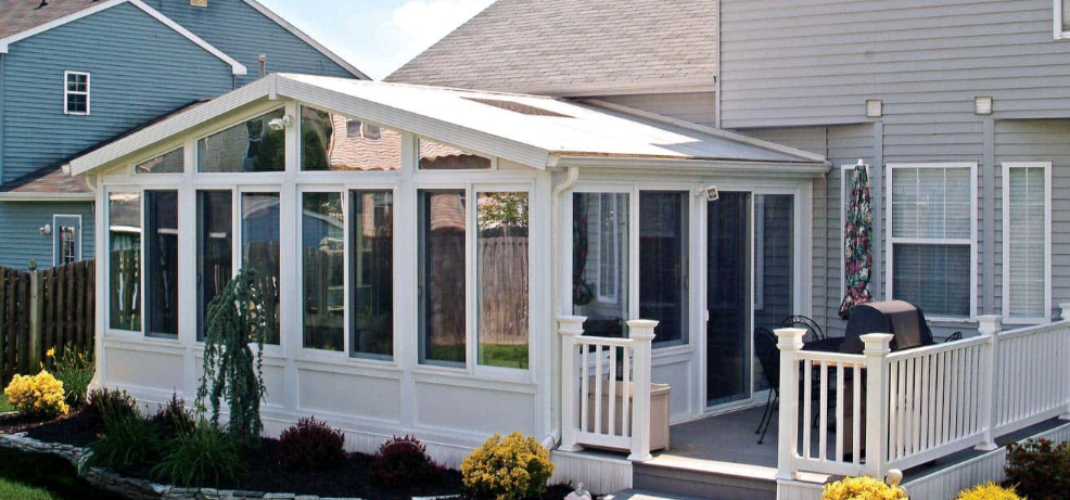 White four-season sunroom addition built onto a family home